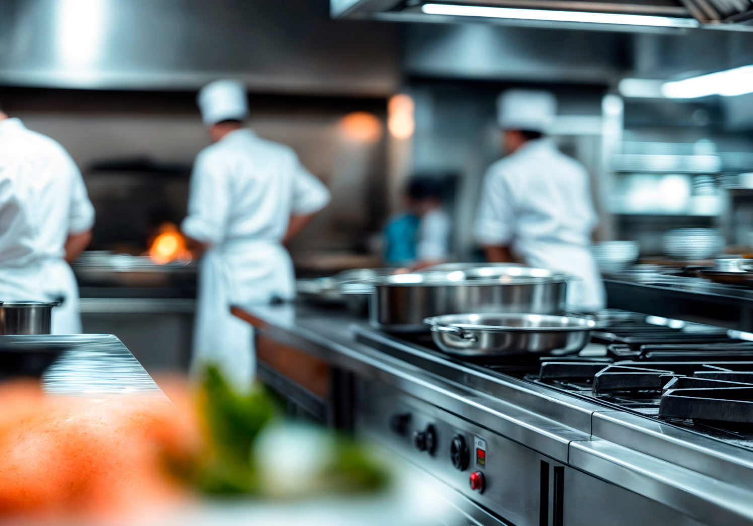 Modern commercial kitchen with chefs working in the back ground cooking food